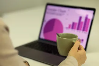 Person working on a laptop with a cup of coffee. by dlxmedia.hu courtesy of Unsplash.