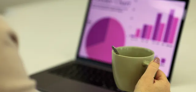 Person working on a laptop with a cup of coffee. by dlxmedia.hu courtesy of Unsplash.
