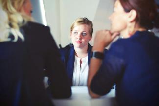 three women sitting beside table by Tim Gouw courtesy of Unsplash.
