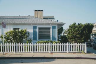 white and blue house beside fence by Gustavo Zambelli courtesy of Unsplash.