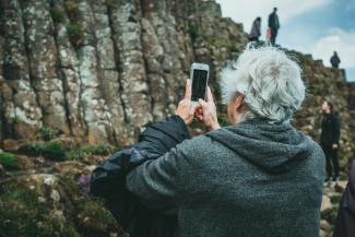 man in black hoodie holding smartphone by Jonathan Cooper courtesy of Unsplash.