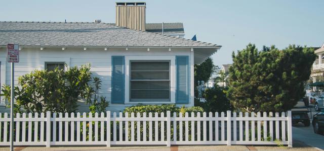 white and blue house beside fence by Gustavo Zambelli courtesy of Unsplash.