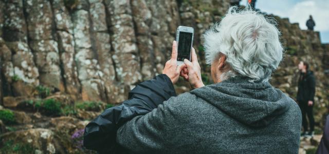 man in black hoodie holding smartphone by Jonathan Cooper courtesy of Unsplash.